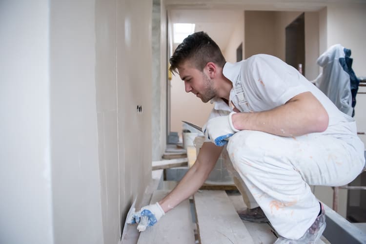 construction worker plastering on gypsum walls